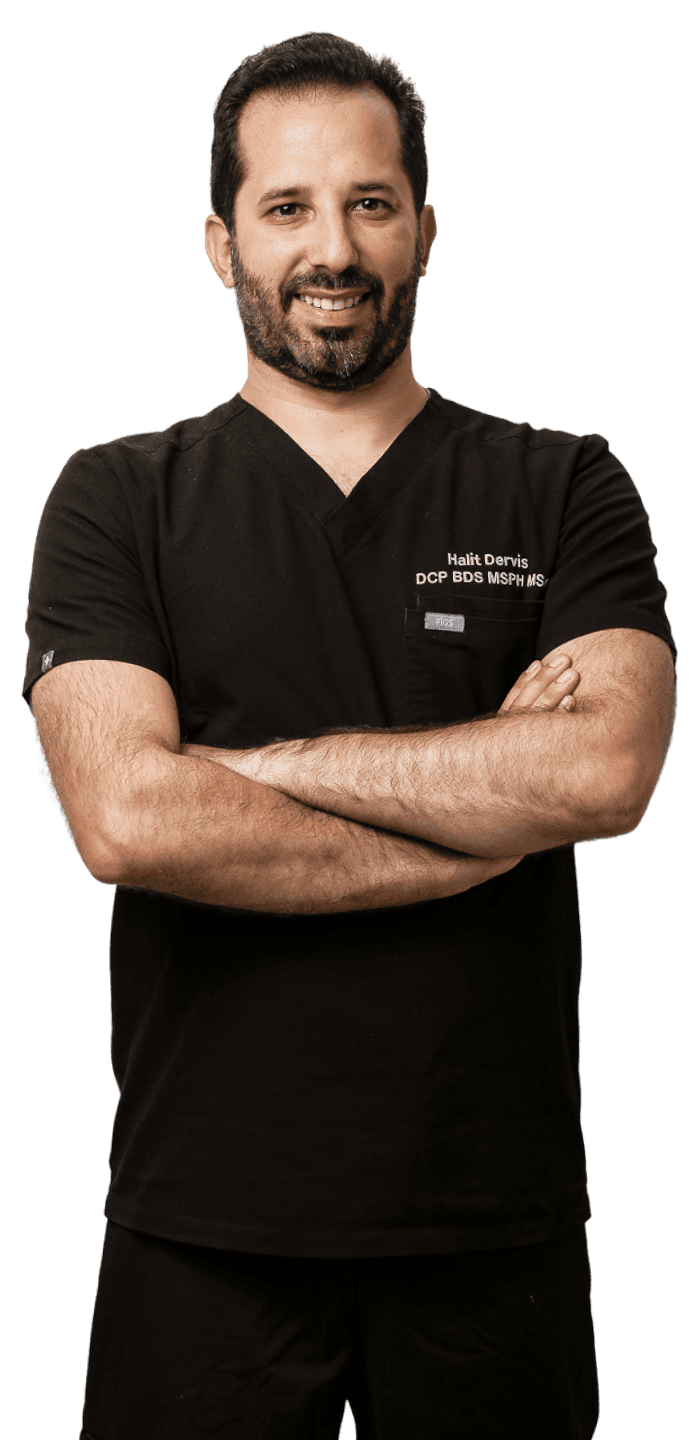 Halit Dervis professional healthcare worker in London, smiling confidently with arms crossed.